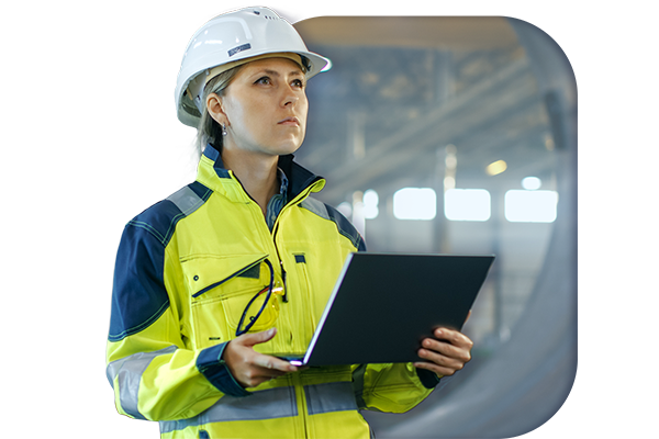 An auditor in PPE performing an audit whilst holding a laptop